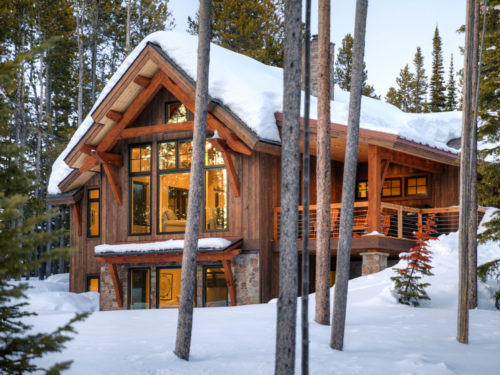 Exterior of great room -- 2 story gable surrounded by snowy trees